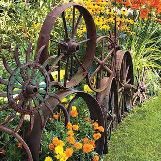 Alte, rostige Wagenräder aus Metall als Dekoration im Garten.