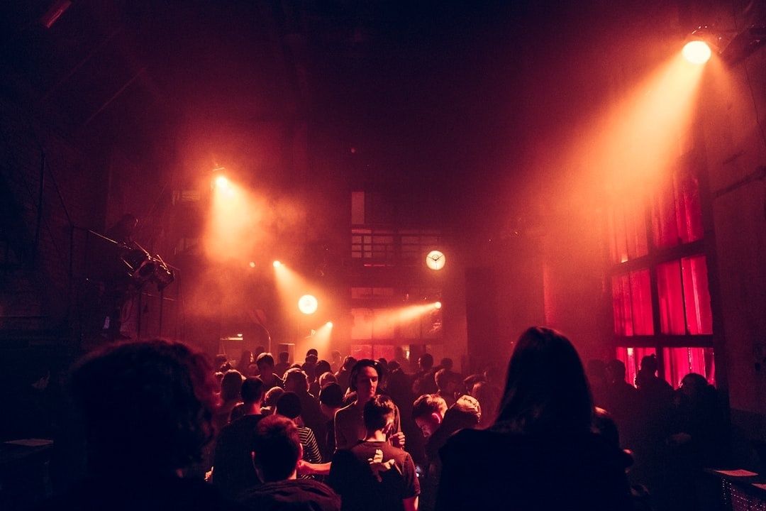 Dicht gedrängte Clubmenge im warmen roten Licht einer langen Partynacht