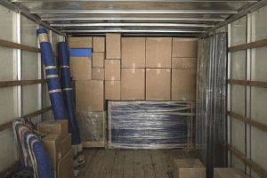 Blick in einen beladenen Transporter mit Umzugskartons und Equipment.